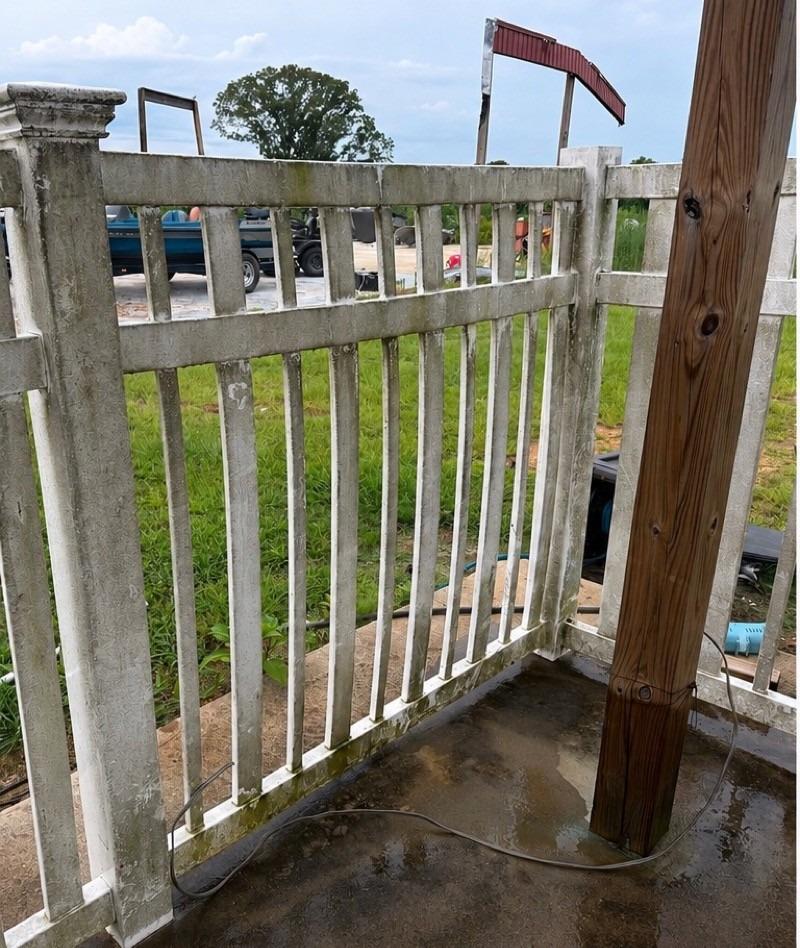 Mildew stained white vinyl fence before cleaning